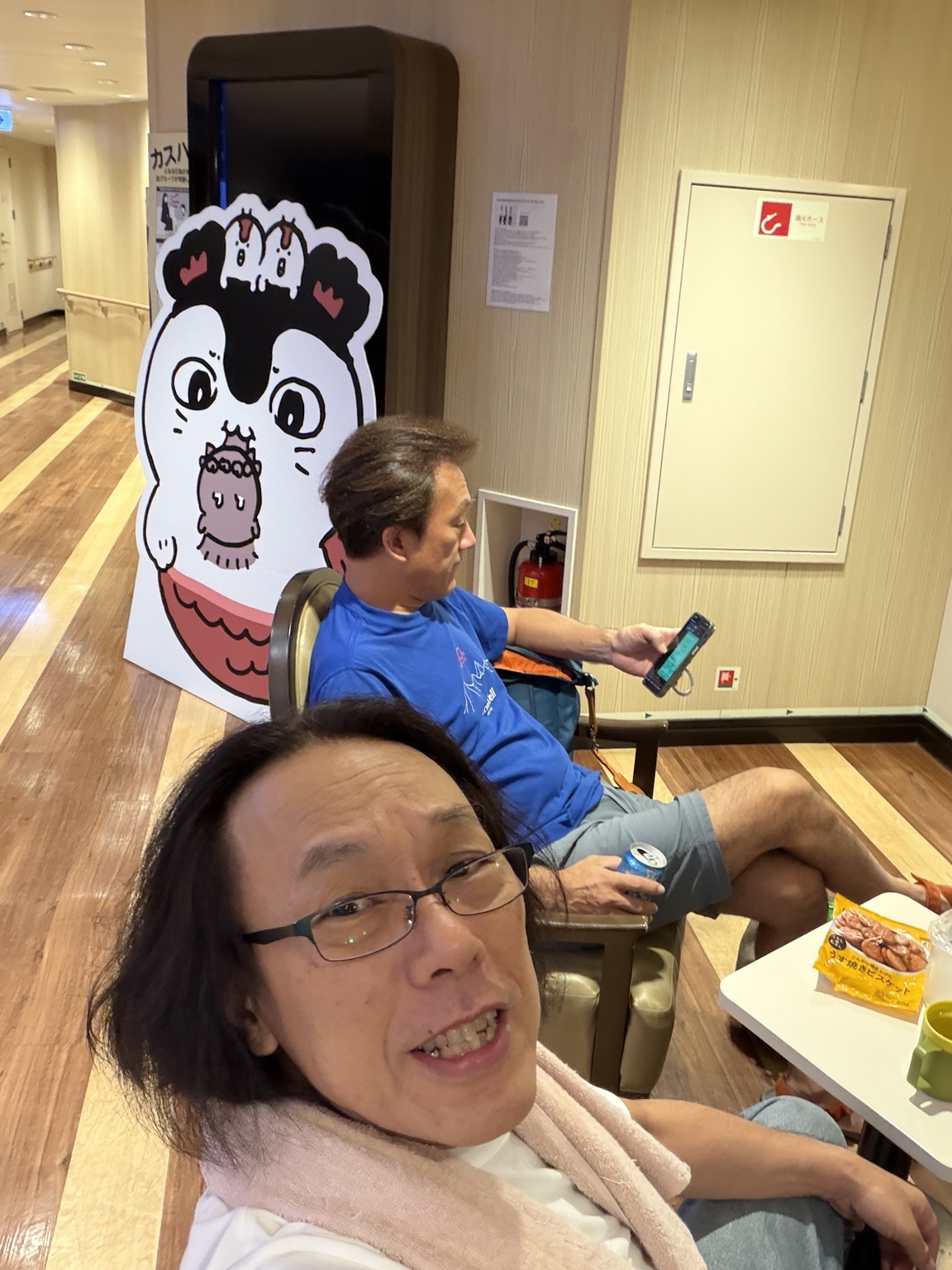 フェリーの窓に向かって座る荒川とおると諏訪光風